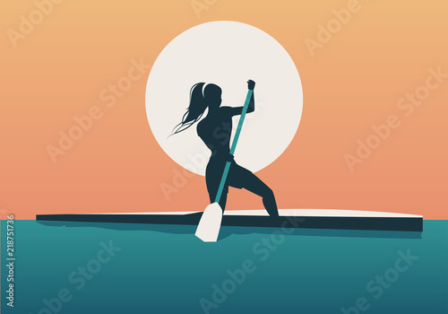 Athlete girl with hair in the wind practicing sporty rowing in a canoe