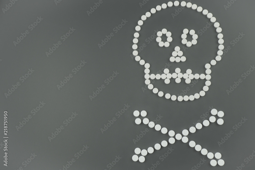 Skull and bones of white tablets on grey background Skull and bones of white tablets on grey background