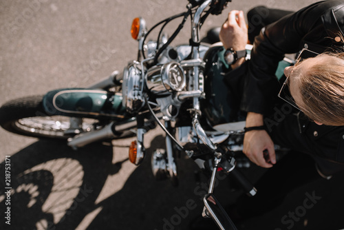 overhead view of biker sitting on vintage classical motorcycle © LIGHTFIELD STUDIOS