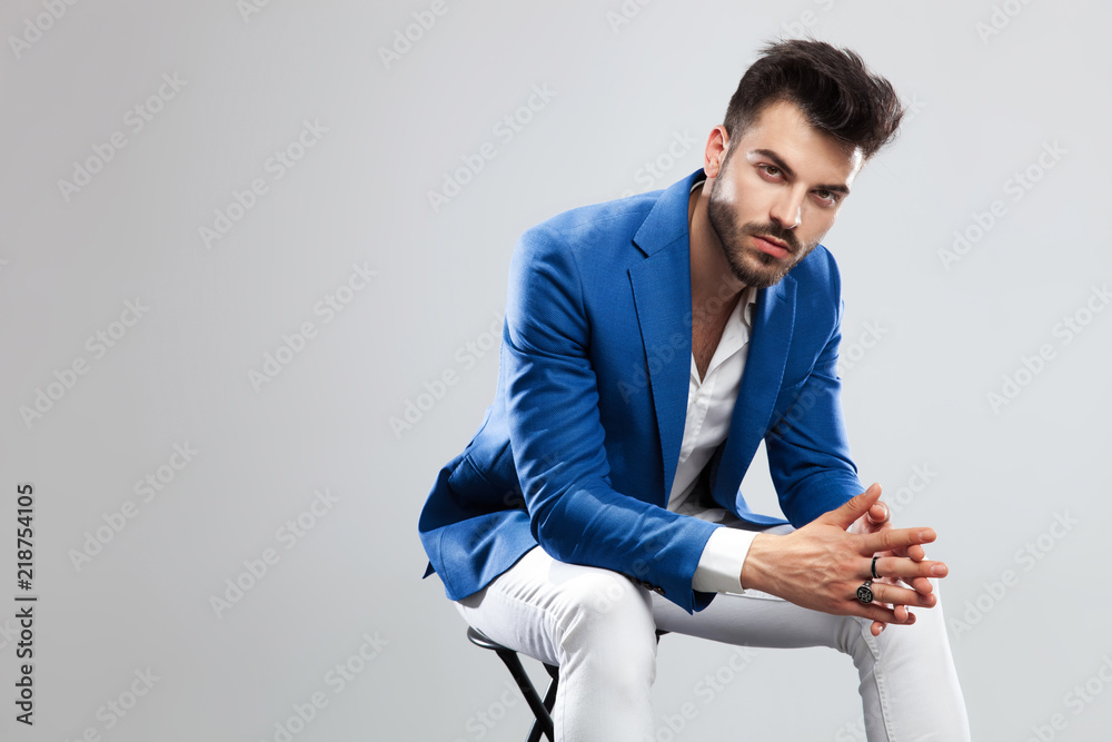 handsome smart casual man sitting and leaning forward handsome smart casual man sitting and leaning forward