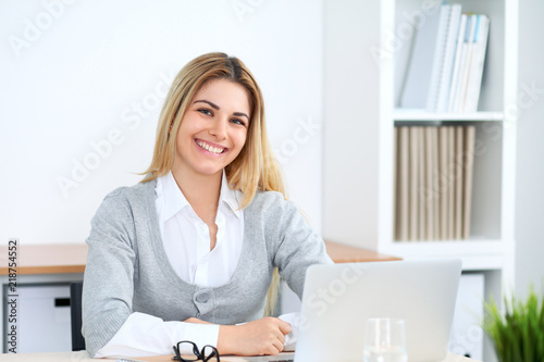 Young business woman or student girl working at office workplace with laptop computer photo