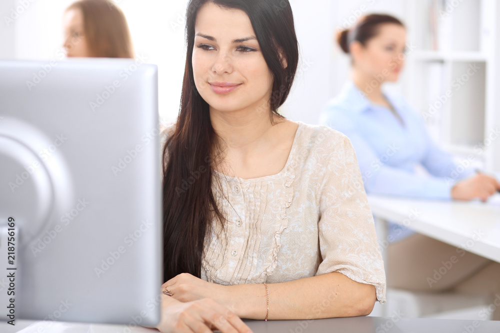 Young businesswoman sitting at desk and while consulting clients. Customer service and business concept Young businesswoman sitting at desk and while consulting clients. Customer service and business concept