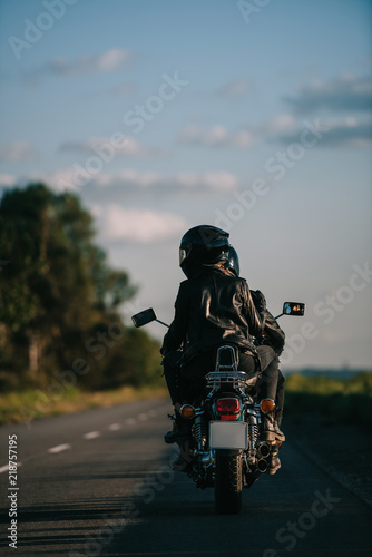back view of bikers in helmets riding motorcycle on country road © LIGHTFIELD STUDIOS