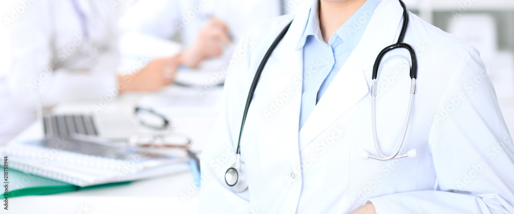Unknown female doctor with medical staff at hospital. Teamwork in medicine Unknown female doctor with medical staff at hospital. Teamwork in medicine