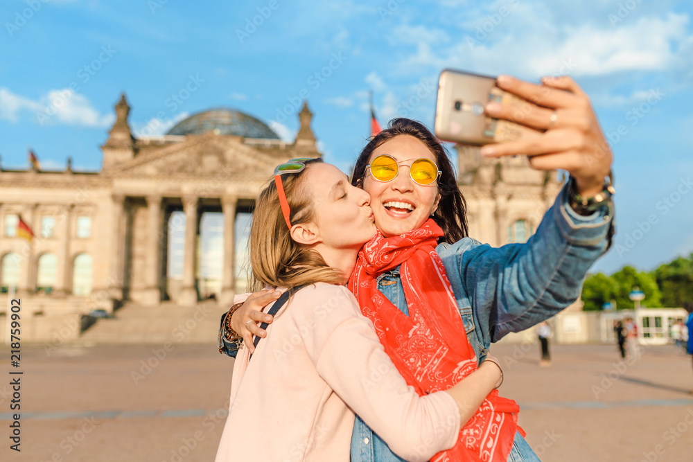 Naklejka premium Dwa szczęśliwa kobieta robi selfie na tle Reichstag Bundestag budynek w Berlin. Koncepcja podróży i miłości w Europie