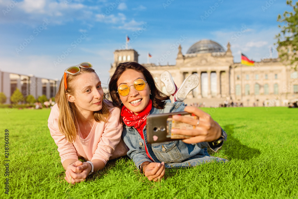 Naklejka premium Dwa szczęśliwa kobieta robi selfie na tle Reichstag Bundestag budynek w Berlin. Koncepcja podróży i miłości w Europie