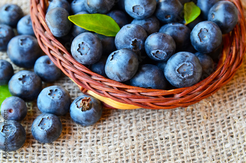 Freshly picked blueberries in a basket on a burlap cloth background.Fresh organic blueberry.Bilberries.Healthy eating,vegan diet or raw food concept.Selective focus.