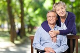 Close-up portrait of an elderly couple hugging in park