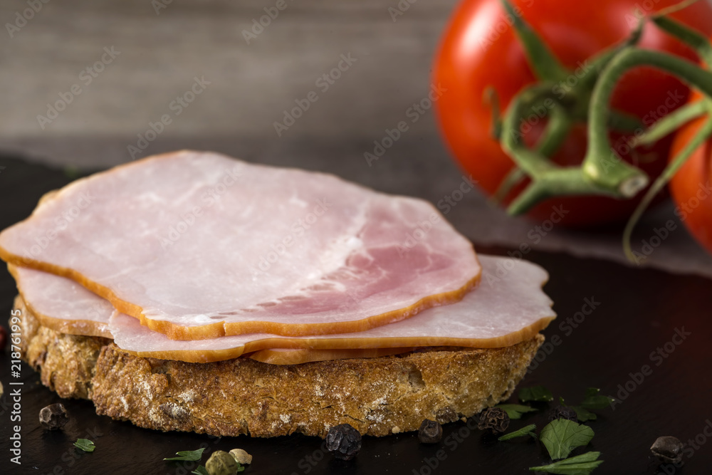 Open sandwich with pork smoked ham on a dark slate Open sandwich with pork smoked ham on a dark slate