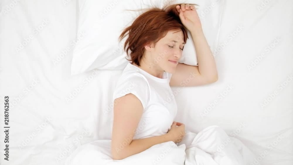 Beautiful young red hair woman sleeping in a white bed. Good morning. Dawn, morning ascent. Female is sleeping. Girl sleeping and resting alone in her bed, dreaming. view from above. Beautiful young red hair woman sleeping in a white bed. Good morning. Dawn, morning ascent. Female is sleeping. Girl sleeping and resting alone in her bed, dreaming. view from above.