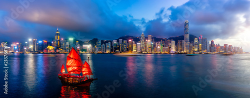 Panorama of Hong Kong City skyline with tourist sailboat at night. View from across Victoria Harbor HongKong. © Travel man