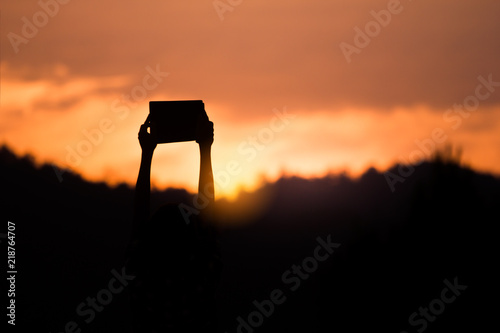 Children holding Bible with light sunset background, christian silhouette concept.