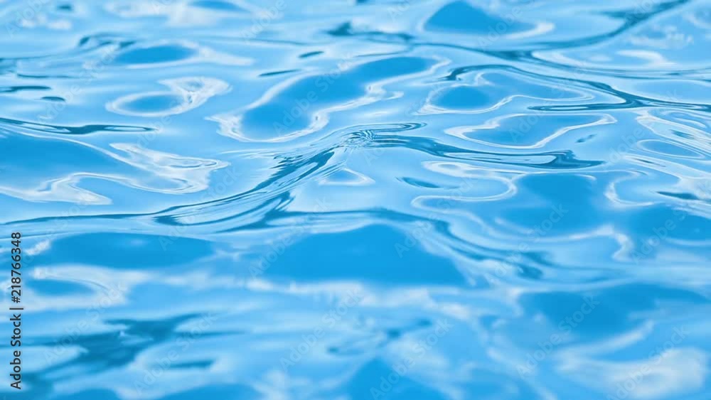 Day shot of crystal blue surface of water in swimming pool in the seaside resort on warm sunny day Day shot of crystal blue surface of water in swimming pool in the seaside resort on warm sunny day