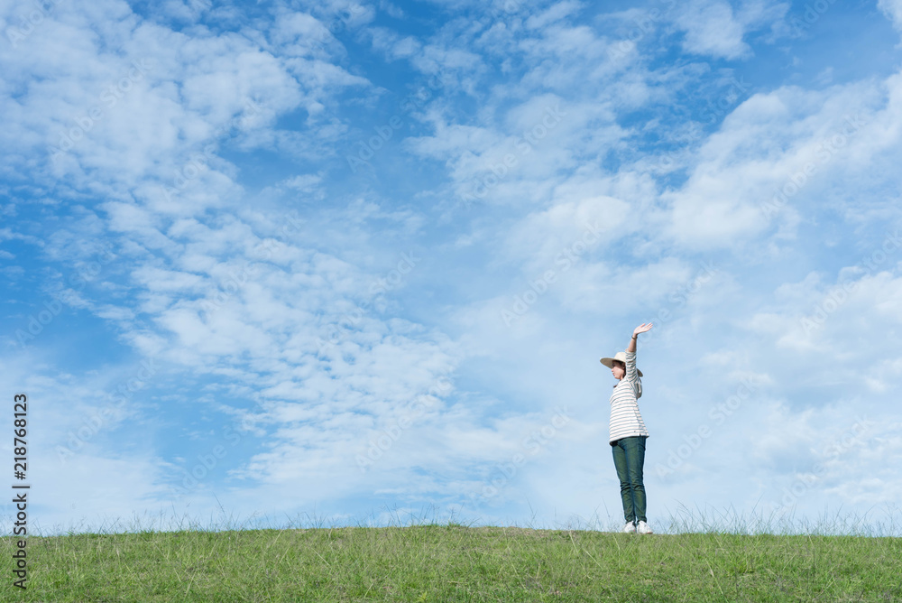 Standing woman raised her hands on the mountain, natural green and beautiful sky. Standing woman raised her hands on the mountain, natural green and beautiful sky.