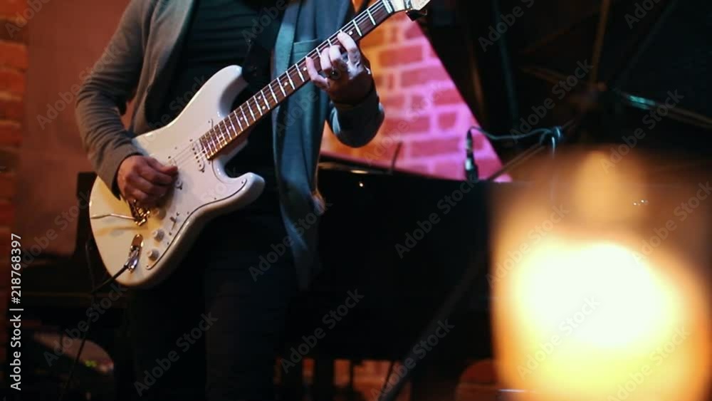 A man plays guitar at a party in a jazz bar, in the frame only his hands A man plays guitar at a party in a jazz bar, in the frame only his hands