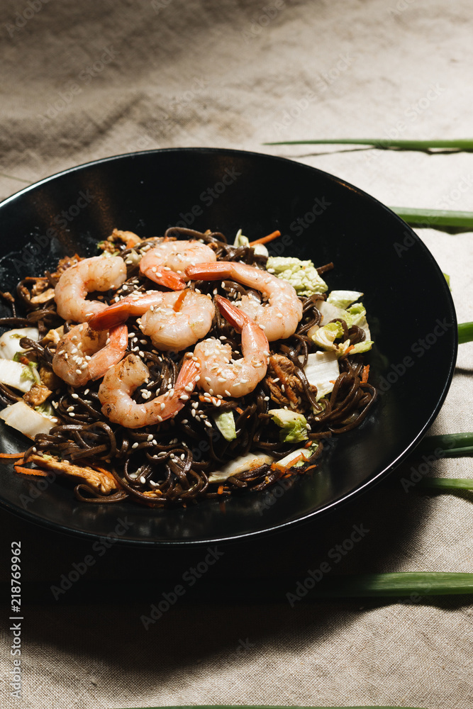 Delicious meal with shrimps in black plate, traditional Aisan food