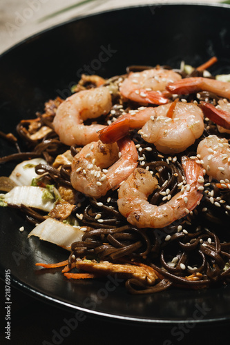 Delicious meal with shrimps in black plate, traditional Aisan food