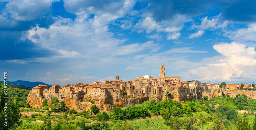 Fototapeta premium Panorama średniowiecznego miasta Pitigliano znajduje się na skraju urwiska, z pięknymi chmurami na niebie, Toskania. Włochy. Europa