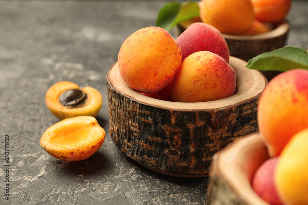 Creative wooden bowl with ripe sweet apricots on grunge background Creative wooden bowl with ripe sweet apricots on grunge background