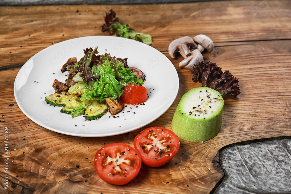 Plate with delicious vegetable salad on wooden table Plate with delicious vegetable salad on wooden table