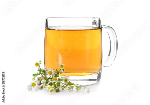 Glass cup of camomile tea on white background