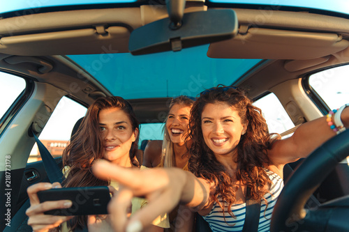 Three female friends enjoying traveling in the car. © Zoran Zeremski