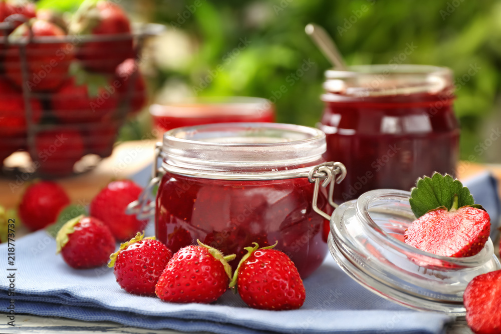 Glass jar with delicious strawberry jam on table Glass jar with delicious strawberry jam on table
