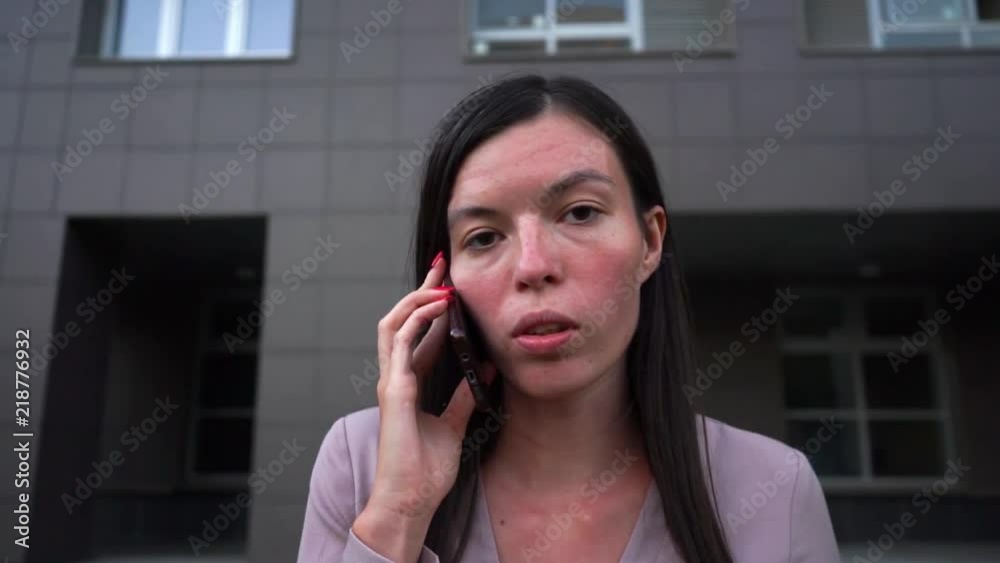 business serious young girl talking on the phone city background MCU business serious young girl talking on the phone city background MCU