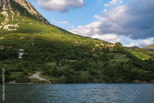 Onboard morning Lake Komani ferry from Fierza to Koman in Albania - tiny church at the foot of the mountain