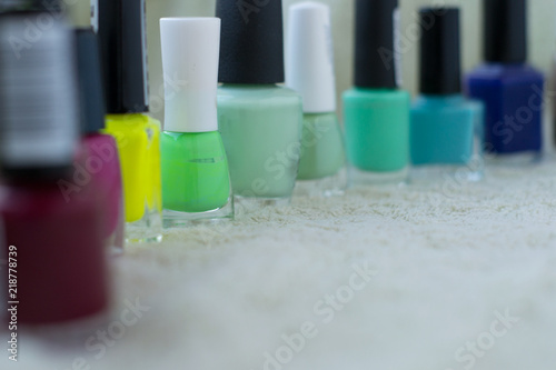 lot of bottles nail polish standing on green background
