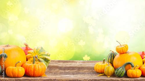 pile of orange pumpkins on wooden table over fall background banner with copy space