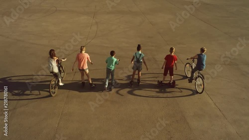 Wallpaper Mural Team of children riding on wheeled vehicles (bicycles, scooters and roller skates) rolling with their back to the camera Torontodigital.ca