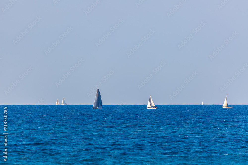 Six yachts with white and gray sails on Mediterranean Sea