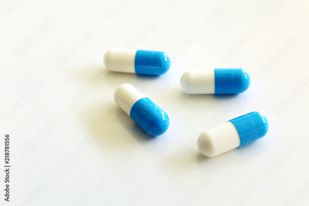 Capsules, white and blue. White background. Capsules, white and blue. White background.