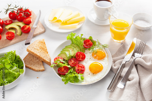 healthy breakfast with fried eggs  avocado  tomato  toasts and coffee