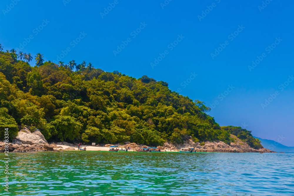Overview of Rawa beach (Pulau Rawa), near Perhentian Kecil in Malaysia. Surrounded by rocks and forest, Rawa beach is a popular snorkelling destination for tourists which are brought by motorboats.