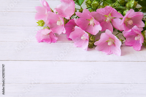 A bouquet of pink wildflowers on a white wooden table