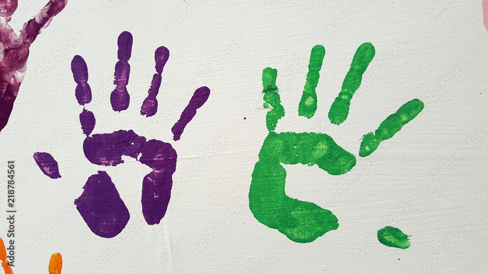 Colored prints of children and adults palms on white background. Colored prints of children and adults palms on white background.