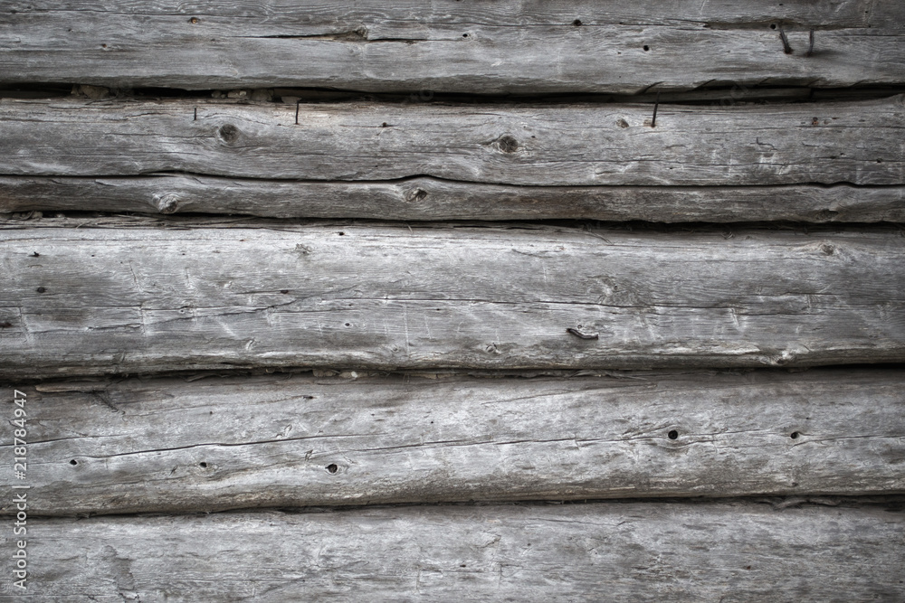 Obraz premium Rough old weathered log cabin background wall closeup