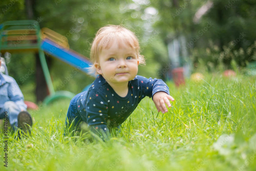 sweet little baby crawls on all fours on the grass sweet little baby crawls on all fours on the grass