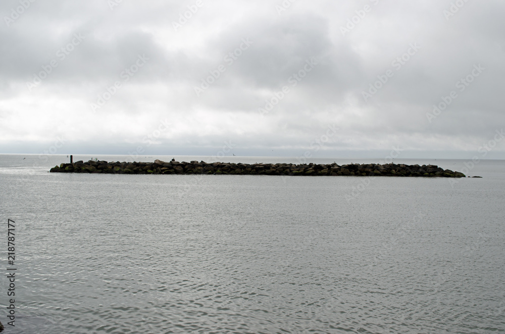 Island with cloudy sky background. Coastline, water