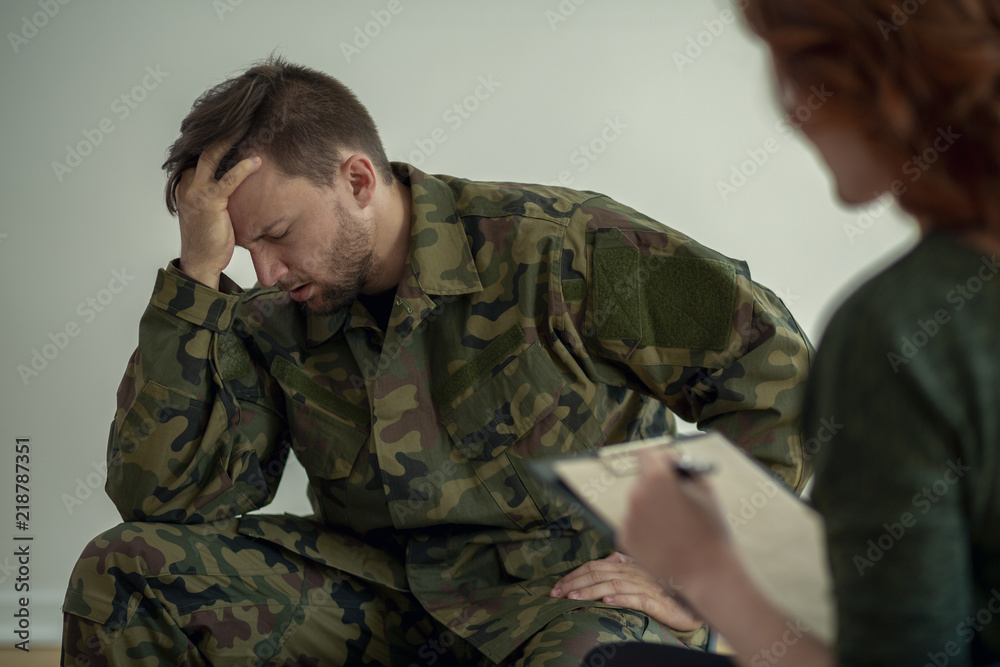 Soldier in green uniform with depression during appointment with psychiatrist