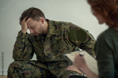 Soldier in green uniform with depression during appointment with psychiatrist