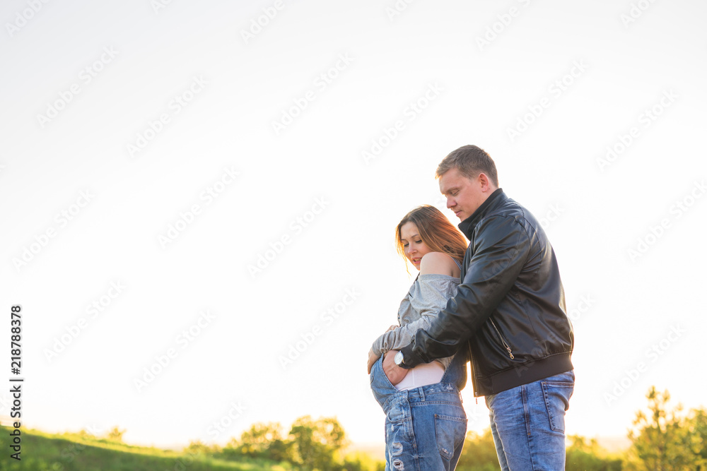 Family, pregnancy and people concept - Pregnant woman with husband in nature Family, pregnancy and people concept - Pregnant woman with husband in nature