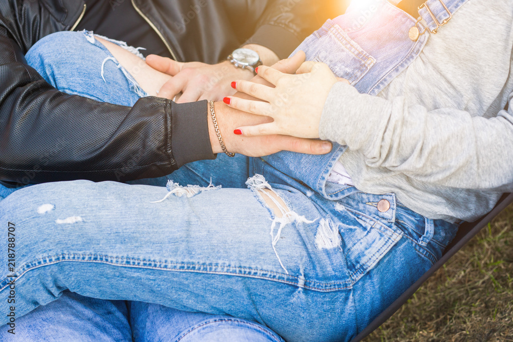 Close up of parents hands touching pregnant belly
