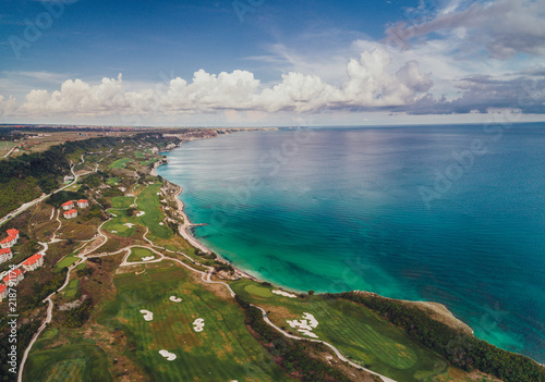 Aerial panoramic view of a golf course next to the cliffs and Black sea. Golfing fields landscape.