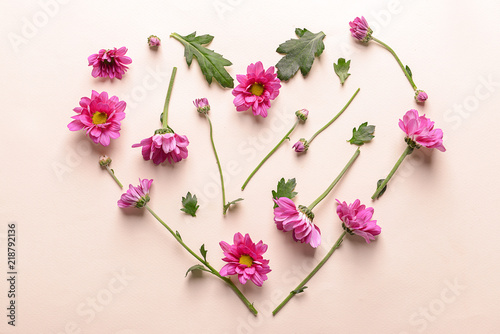 Heart made of beautiful flowers on light background