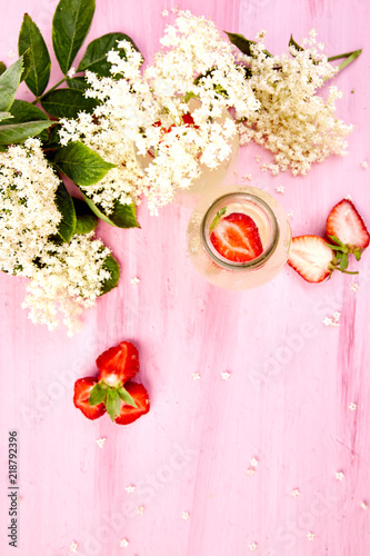 Kombucha tea with elderberry flower and strawberry on pink background