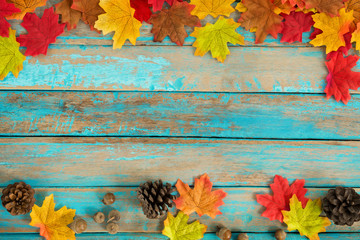 Beautiful frame composed of  autumn maple leaves with pine cones on wood plank. nature fall season background.