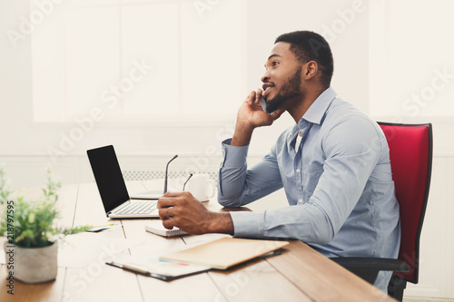 Young black businessman talking on mobile phone